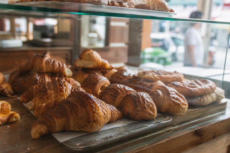 A display of golden, flaky croissants and laminated pastries at an artisan bakery