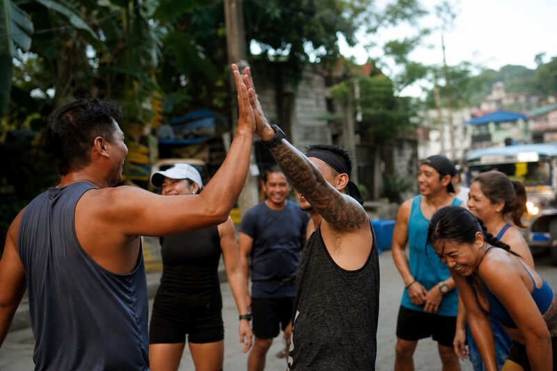 Runners celebrating and high-fiving at the finish of a group run