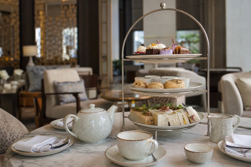 Elegant hotel lobby afternoon tea service with tiered stands and pastries