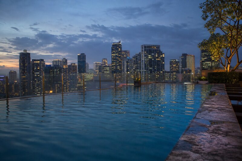 High-rise hotel pool deck overlooking the BGC skyline at dusk