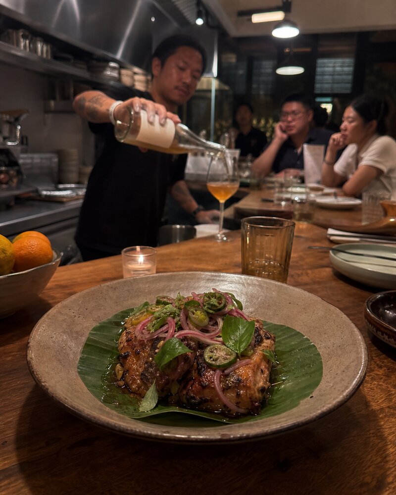 The warm, intimate interior of a new Manila restaurant at night with a small chef's counter and pendant lighting