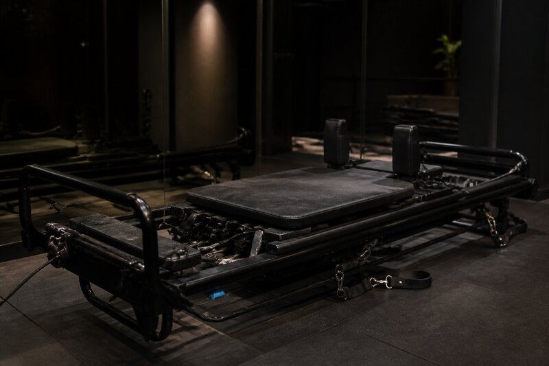 A Lagree Megaformer machine in a dark-toned boutique studio