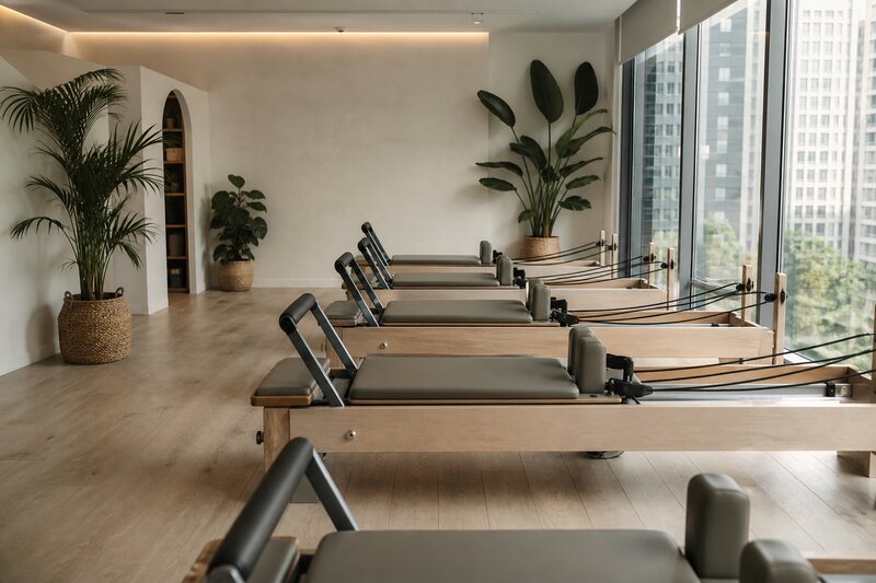 The airy minimalist interior of a boutique reformer Pilates studio in BGC with a row of reformers